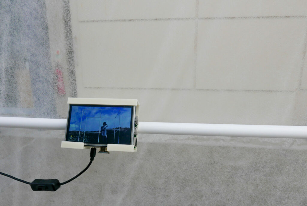 raspberry pi screen of person in the portable bus stop with blue sky in a 3D casing